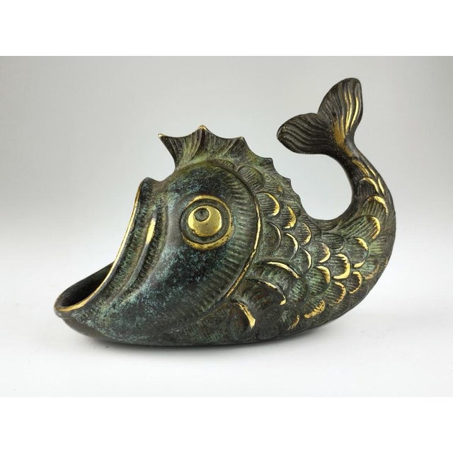The large ashtray has a green patina and measures 11 cm wide, 8.5 cm high, and 6.5 cm deep. The smaller, black patina...