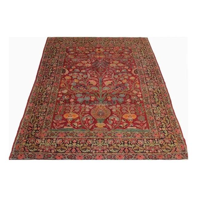 This traditional old handwoven Tabriz area rug features a directional floral design. The luxurious field of red is...