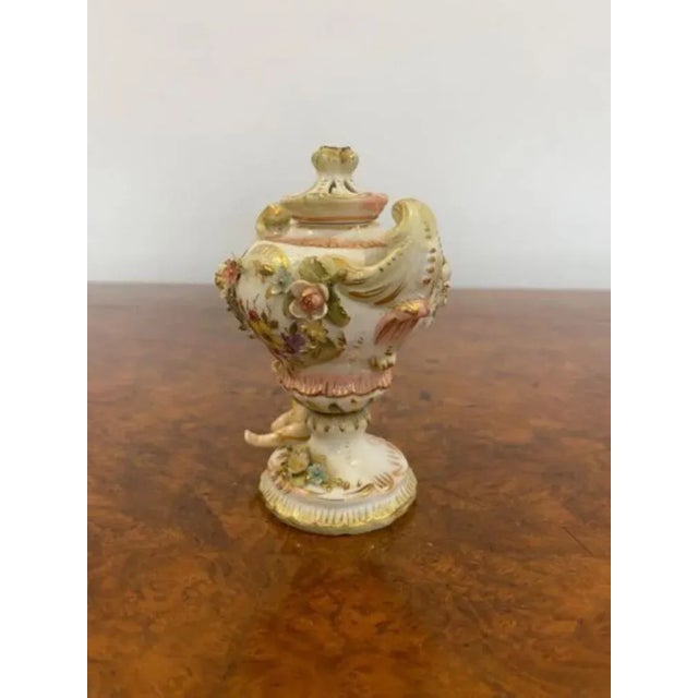Antique small porcelain vase, having lovely flowers with a cherub looking up to the vase hand painted in wonderful pastel...