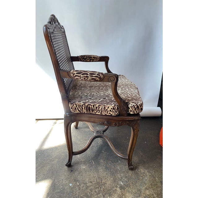 Louis XV style caned walnut arm chair. Velvet upholstered cushion and arm rests.