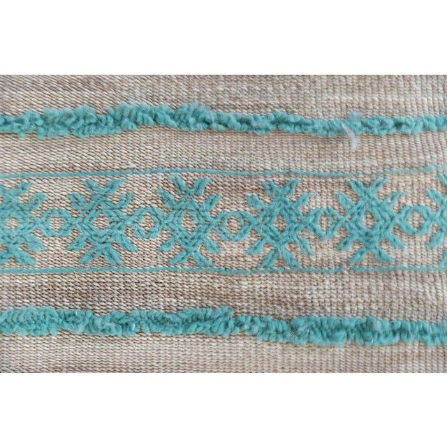 This contemporary Moroccan-inspired rug features a serene composition of horizontal bands rendered in soft teal and pale...