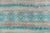 This contemporary Moroccan-inspired rug features a serene composition of horizontal bands rendered in soft teal and pale...