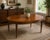 This vintage oval dining table features a beautifully bookmatched walnut veneer top with a striking sunburst grain pattern...