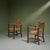 This pair of wicker armchairs from the 1940s features a darker oak frame with a lighter seagrass rope seating and...