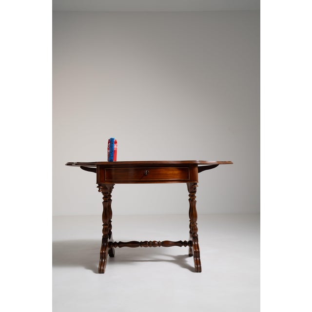 A practical Pembroke table with drop-leaf functionality, allowing for flexible use of space. Crafted in mahogany, the...