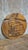 A distinctive vintage carved wooden wall plaque featuring a circular form with a raised sculptural relief. The composition...