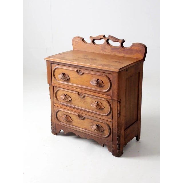 Elegant antique three-drawer chest with beautifully carved leaf-form pulls and a decorative carved back rail. Classic...