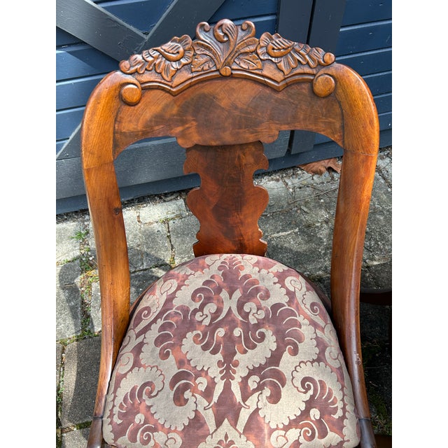 A pair of mid 19th Century side chairs, beautifully hand carved and newly upholstered seats with authentic Fortuny fabric.