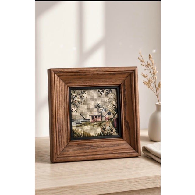 This is a vintage solid wood framed needlepoint (needlepoint/tapestry-style embroidery on canvas) depicting a soft,...