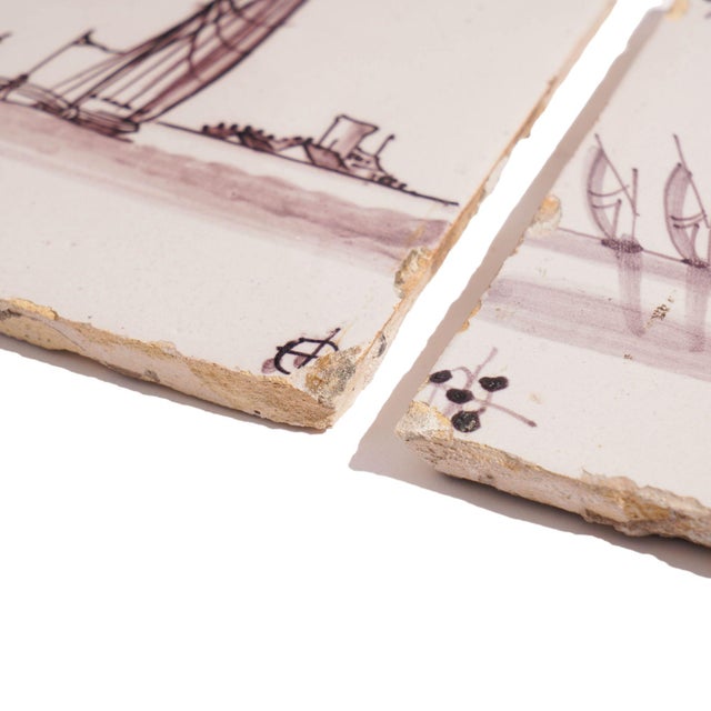 Two square mulberry faience tiles of sailing vessels along a shoreline. Holland, early 18th century.