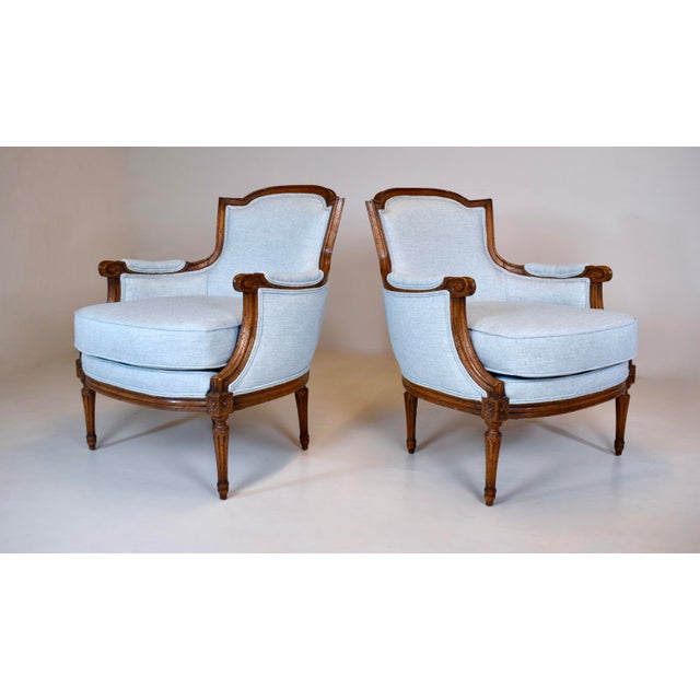 An exquisite pair of Louis XVI style Bergere chairs by Baker Furniture, fully restored with new powder blue cotton...