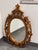 Design Plus Gallery presents a Vintage Rococo Style Oval Mirror. This ornate wall mirror showcases an elongated oval plate...