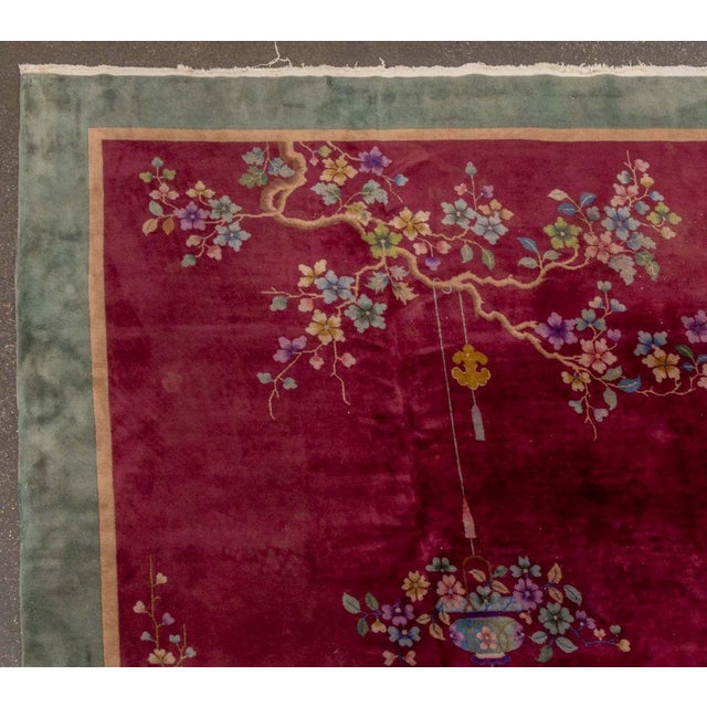 Nichols Chinese Art Deco Pictorial Carpet, with scene of flowers and birds on a plum ground with green border. 12' 6" L x...