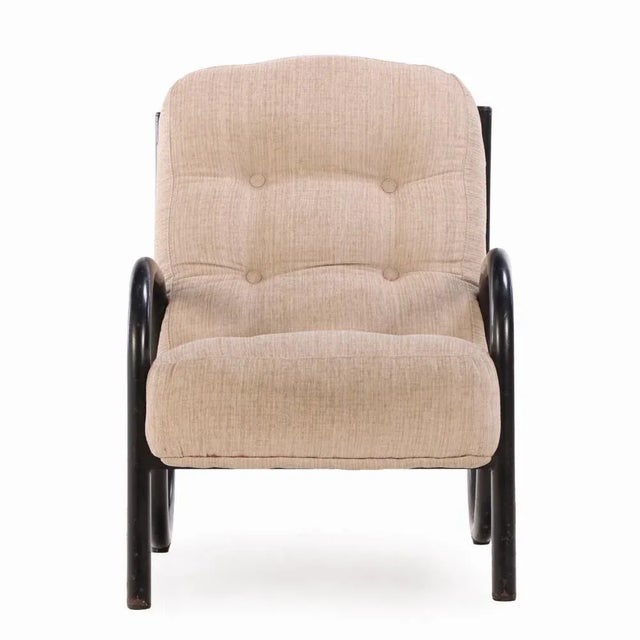 A sculptural French armchair from the 1960s, featuring a sleek tubular iron frame and minimalist form indicative of mid-...