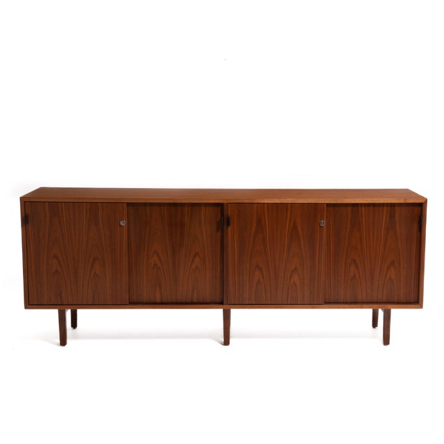 Among my favorite things, a Florence Knoll credenza, four sliding doors with leather pulls. This example is marked on the...