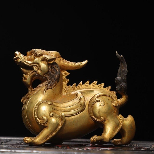 This is a finely crafted antique gilt bronze sculpture of a mythical beast, possibly a stylized Qilin or a similar revered...
