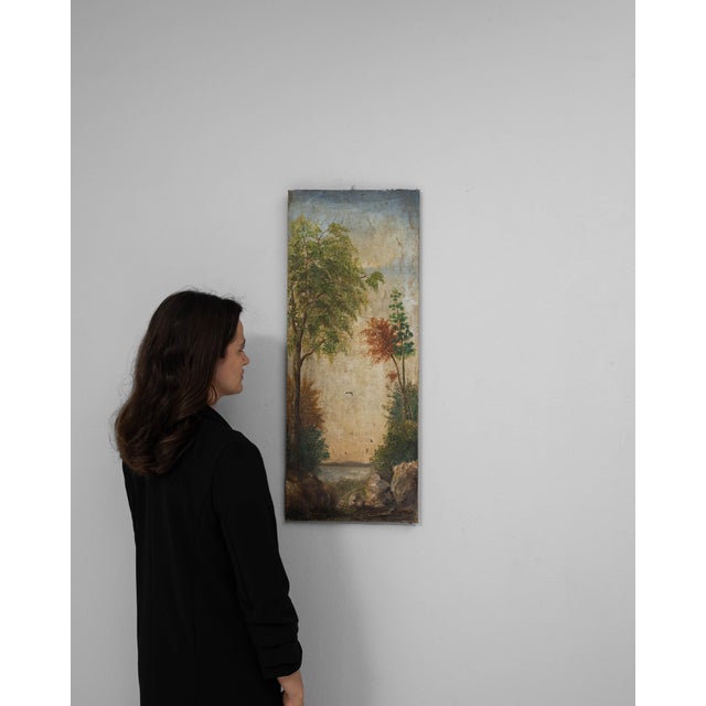 This 19th Century French painting depicts a serene pastoral scene framed by tall, softly rendered trees that guide the...