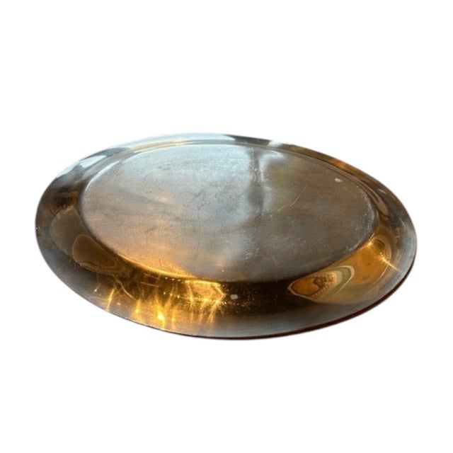 A timeless vintage silver plate serving platter with a clean, understated design. Featuring a smooth oval form with a...