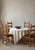 A matching set of four carved oak dining chairs with tall, slender ladder backs and three distinctive scalloped cross...