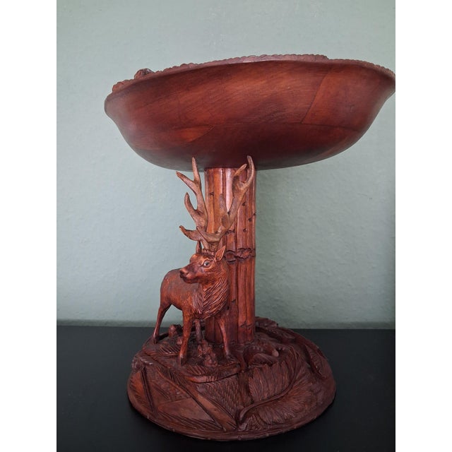 This walnut wood stand was carved in France around the 1950s. The piece features a carved deer with glass eyes and a base...