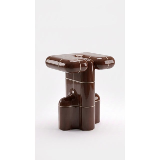 A side table with the presence of a small monument. Stacked curved tiles give it a silhouette that changes from every...