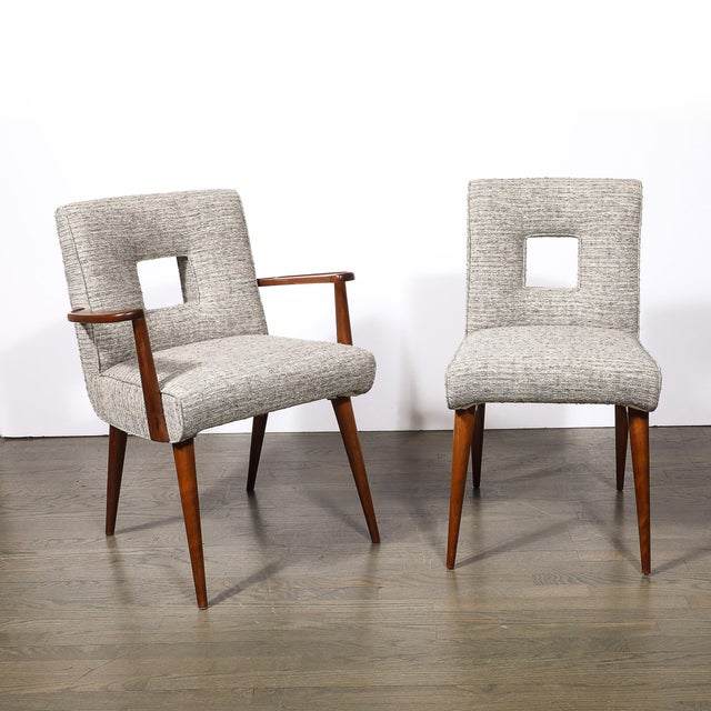 A set of six Mid-Century Modernist arm and side chairs, designed by Paul Frankl, featuring striking cutout backrests and...