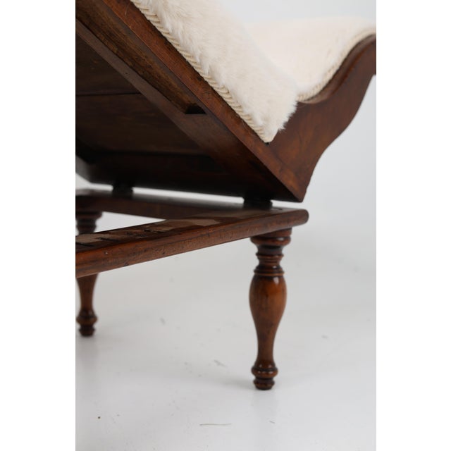 A stylisch Victorian footstool crafted from mahagony, taking the form of a miniature chaise longier with gently curved...