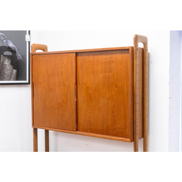 A vintage teak wall untit by Kurt Ostervig for K.P. Mobler. This beautiful vintage piece carries an iconic Danish design...