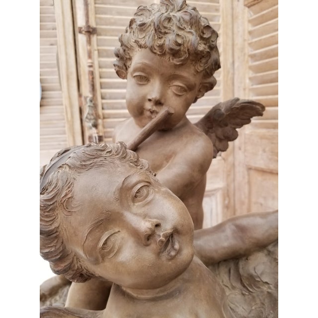 Stunning large terracotta sculpture of cherubs singing and playing a flute featuring a carved open music book, tamberin,...