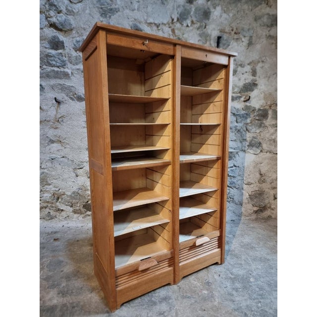 This vintage tambour cabinet originates from France and dates from the 1960s. Crafted from oak, the piece features a warm,...