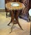A stunning French Empire style center table featuring an elegant scalloped top adorned with intricate floral marquetry...