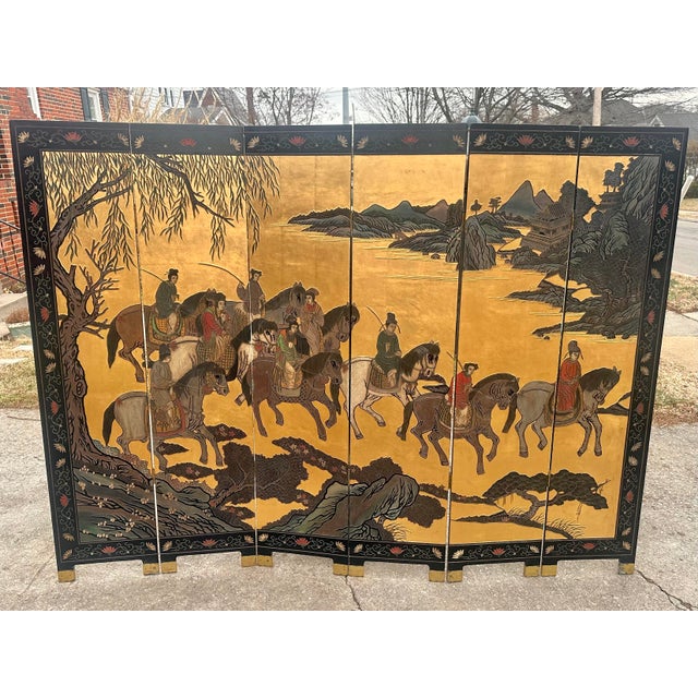 Stunning 20th century Chinese export six-panel coromandel screen with gold leaf. Features an incised landscape with nine...