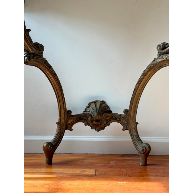 Antique Rococo-style console table featuring an intricately carved wood base with scrolling acanthus motifs and cabriole...