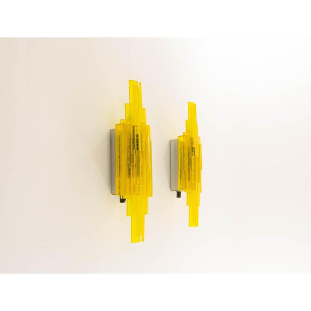 A pair of yellow handmade acrylic wall lamps. The sconces were designed by claus bolby and manufactured by his own...