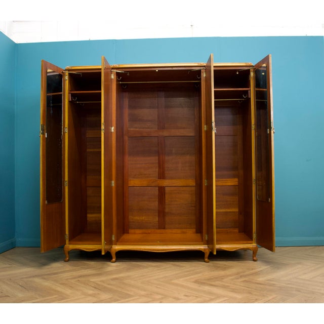 An antique-style walnut wardrobe by Alfred Cox, circa 1950s. These pieces would have been exclusively retailed through...