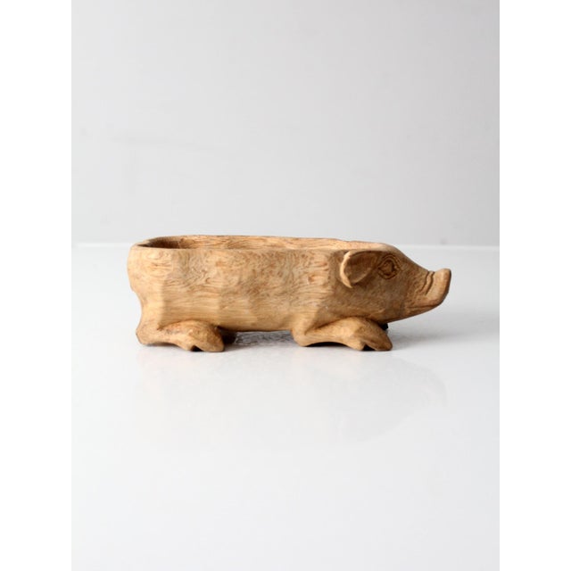 A charming hand carved wood pig bowl with an expressive folk art presence and warm natural tone. Sculpted from solid wood,...