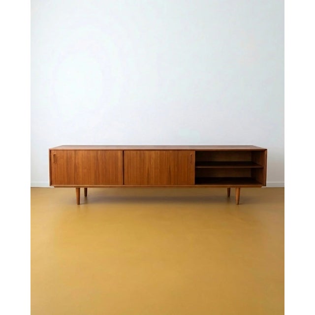 A 1960s Danish teak sideboard, 240 cm long—a dramatic piece, designed to discreetly and elegantly occupy an entire wall....