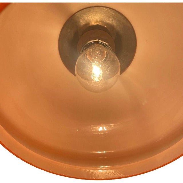 Opaline glass hanging pedant lamp. Orange on the outside and white on the inside wich results in a warm glow. chrome top...