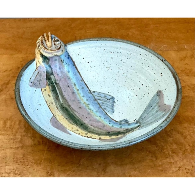 This vintage handcrafted pottery bowl is a captivating study in sculptural and painted artistry, centered around a...