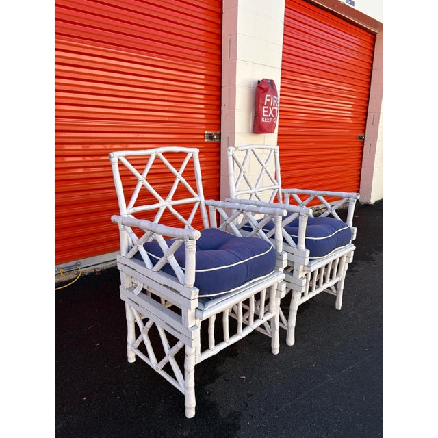 Beautiful pair of Chippendale style armchairs featuring a classic faux bamboo frame and lattice back design. Finished in...