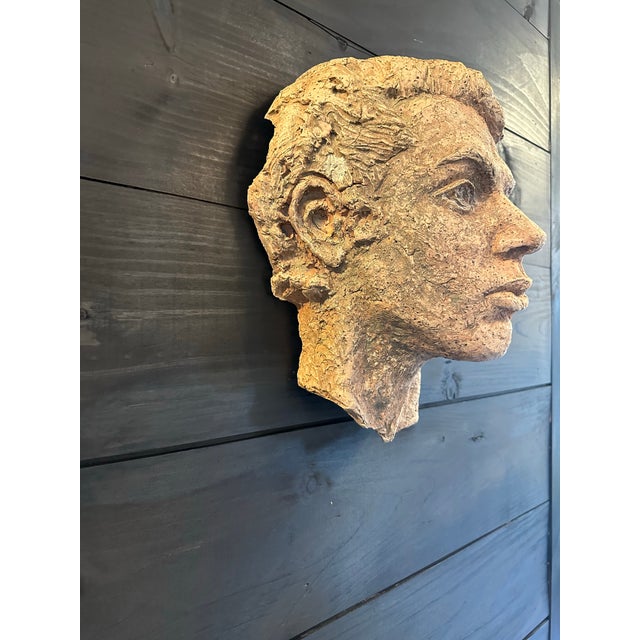 Hand sculpted head made of earthenware. I found this at an estate sale hanging on an outside wall. It has a lovely patina....