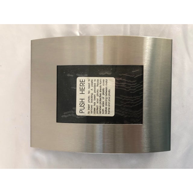 New, never used Nambe convex photo frame Circa 1990’s Measures 8” x 6” Holds a 4.5” x 3” photo Hallmarked on back (see...