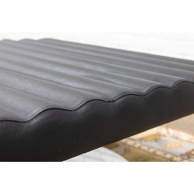 A pair of contemporary modern black leather and chrome ottoman stools. This pair of lovely modern stools feature a lovely...