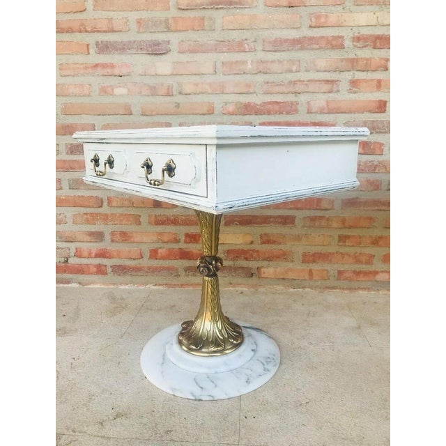 Elegant pair of neoclassical nightstands, each featuring a square top with a single drawer. The wooden structures are...