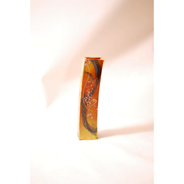 This 1970s ceramic vase embodies the organic and handcrafted aesthetic of its era. Its slender, gently curved shape gives...