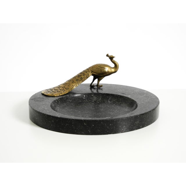 A beautiful, large granite valet tray (*Svuotatasche*) featuring a brass peacock. Original piece from around 1920; likely...