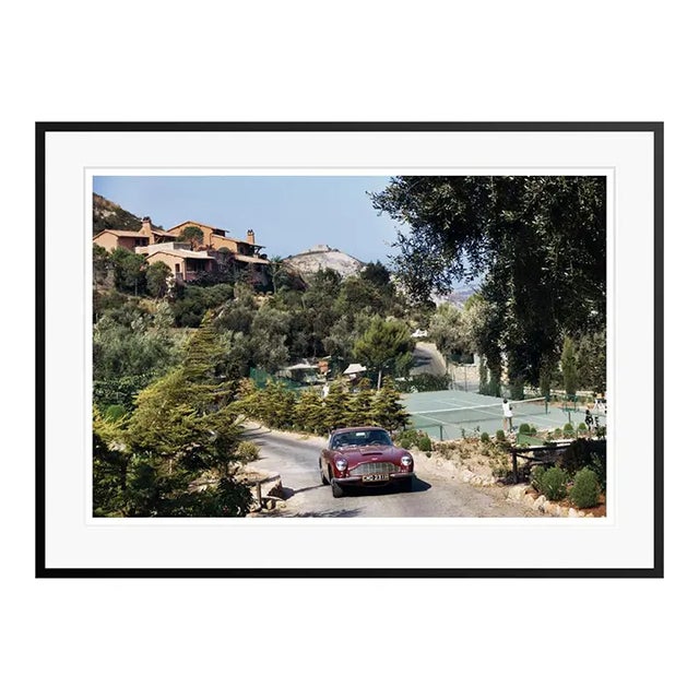 Il Pellicano Tennis 1973 An Aston Martin DB6 sports car driving past the tennis courts at Il Pellicano Hotel in Porto...