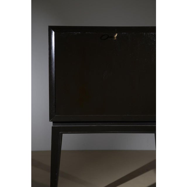 A sophisticated Italian bar cabinet from the 1950s, featuring a minimalist and elegant silhouette. The structure is...