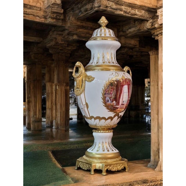 Description: This exquisite pair of urns sits atop intricately decorated porcelain pedestals, each crafted with meticulous...