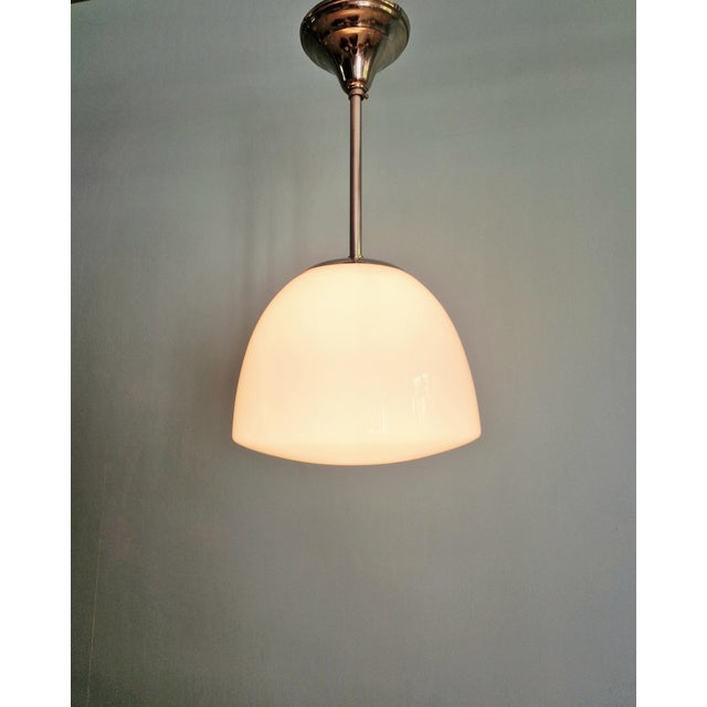 Bauhaus pendant light in chromed metal with a white opaline glass shade, 1930s. The pendant light has been rewired and is...